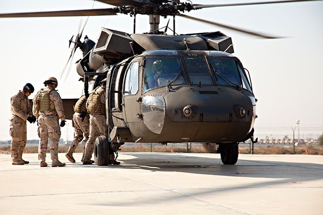 Militaire - Militaire Un groupe de personnes marchant à côté d’un hélicoptère